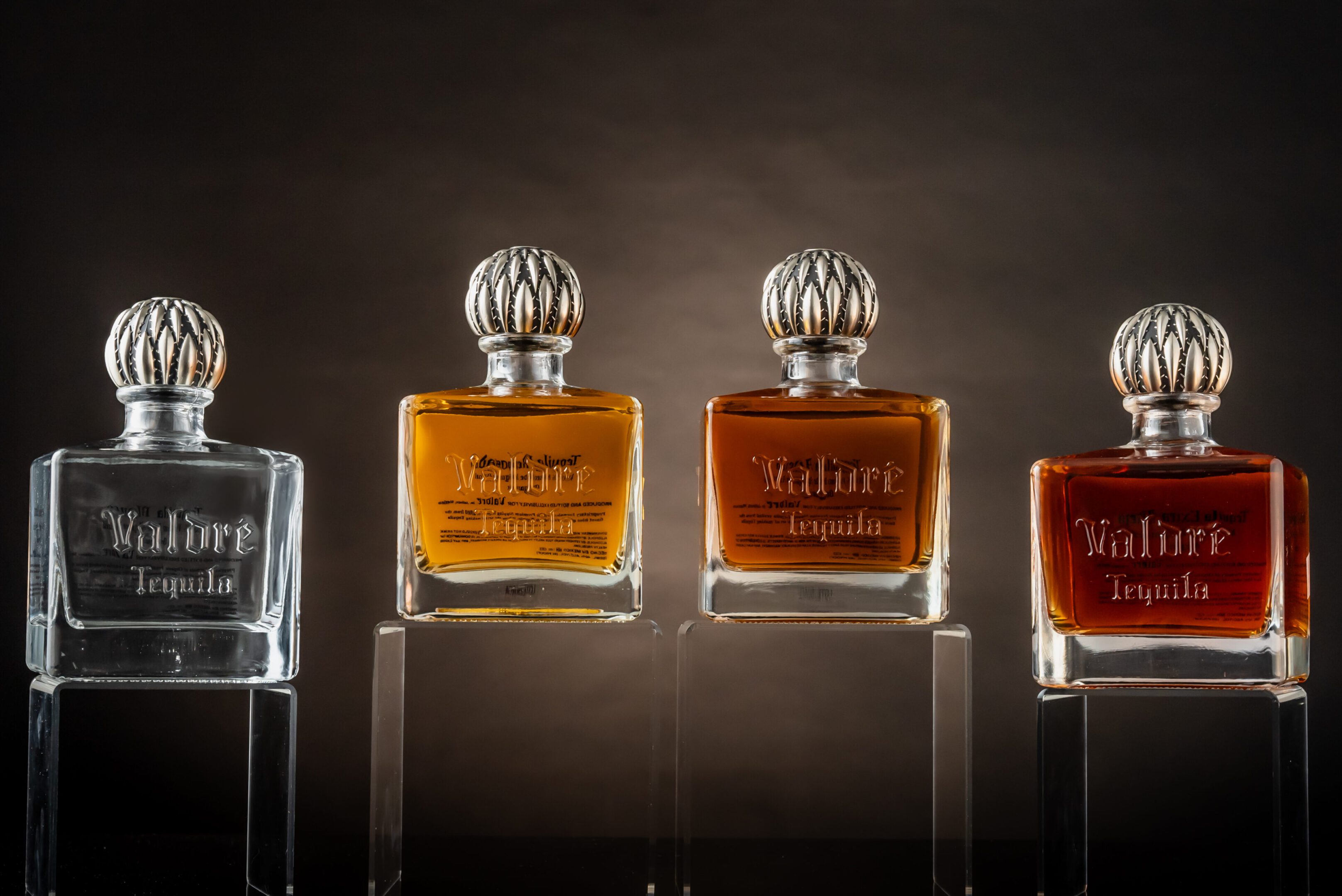 Four bottles of perfume are shown in a row.