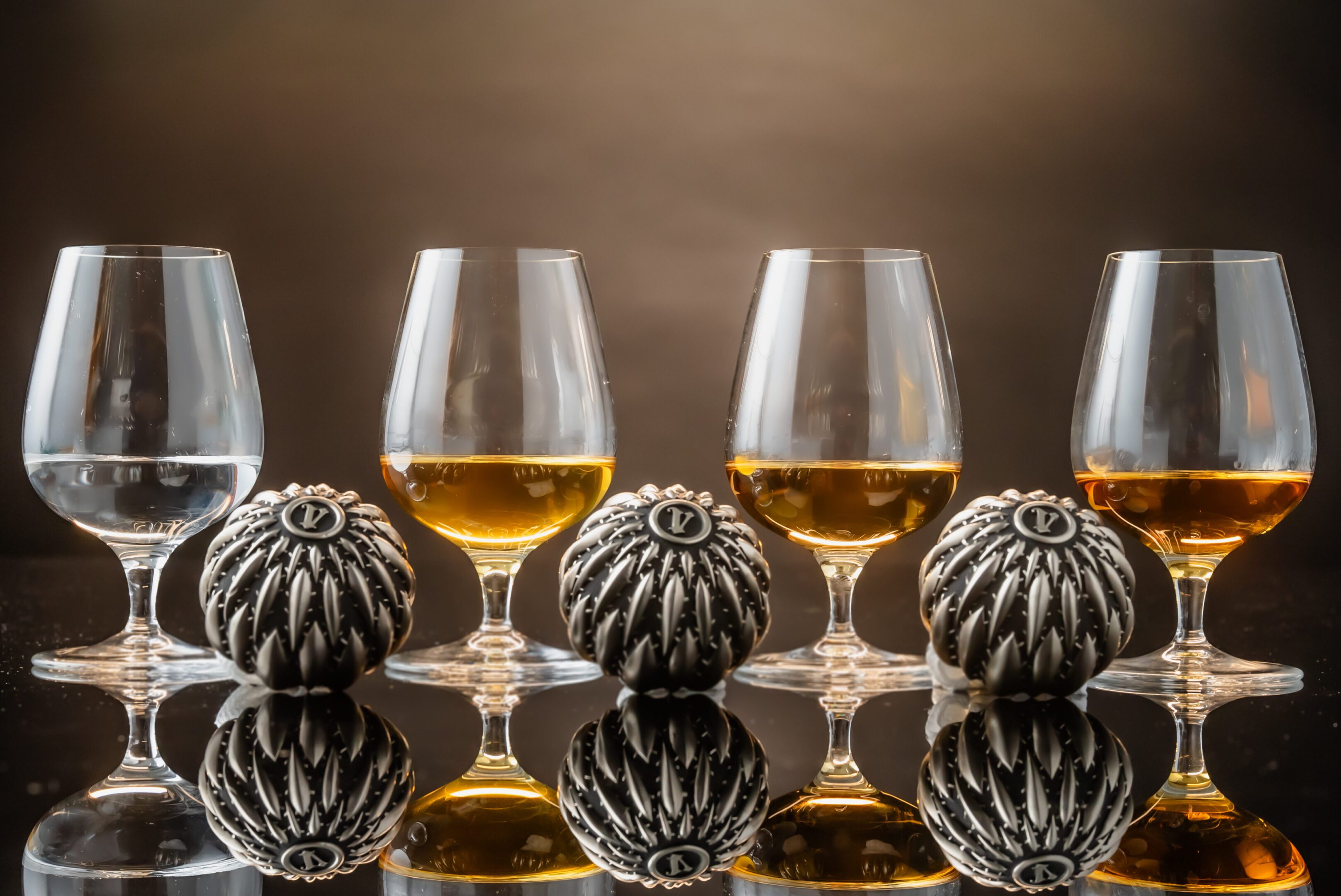 A group of glasses filled with alcohol on top of a table.