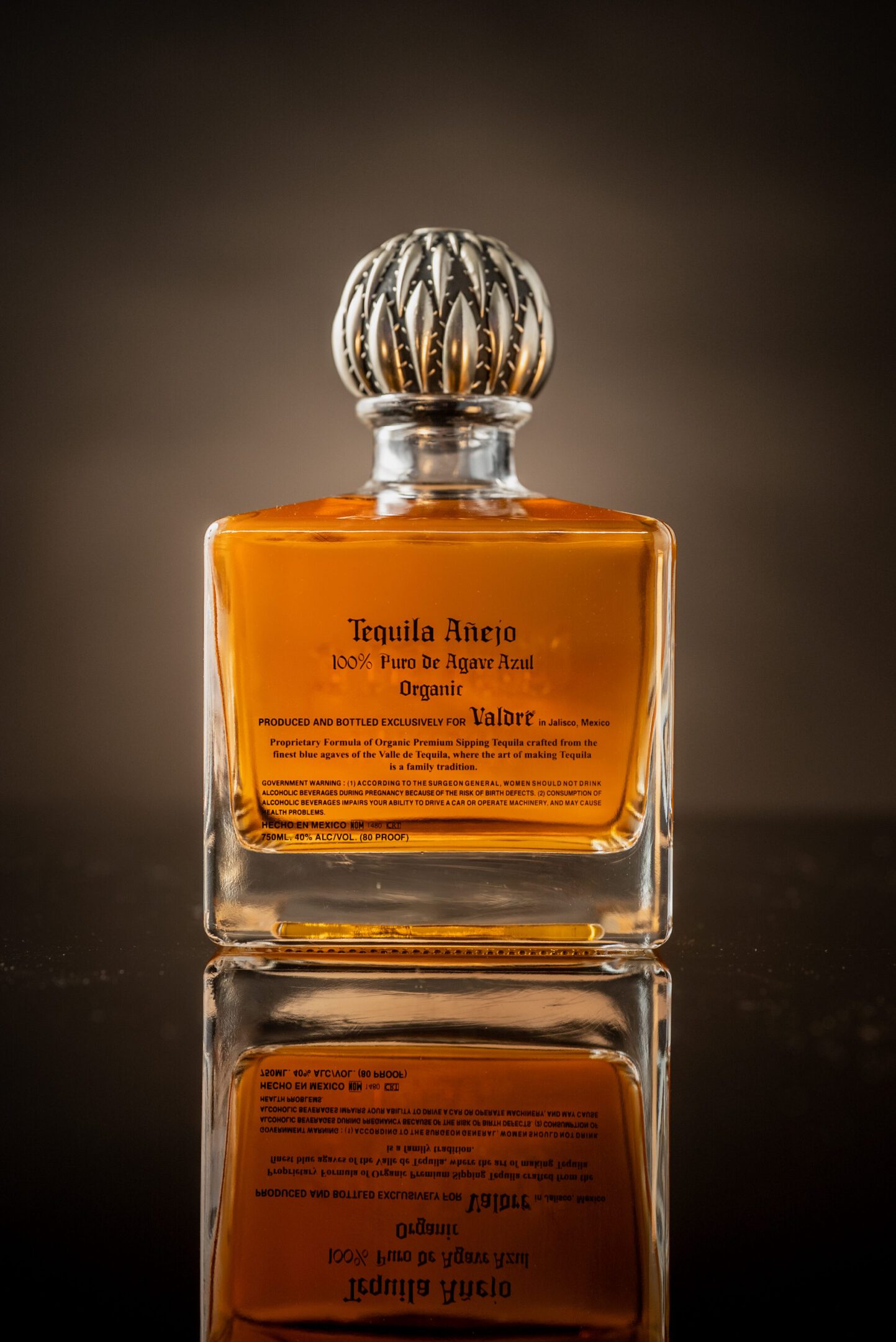 A bottle of tequila anejo on top of a table.
