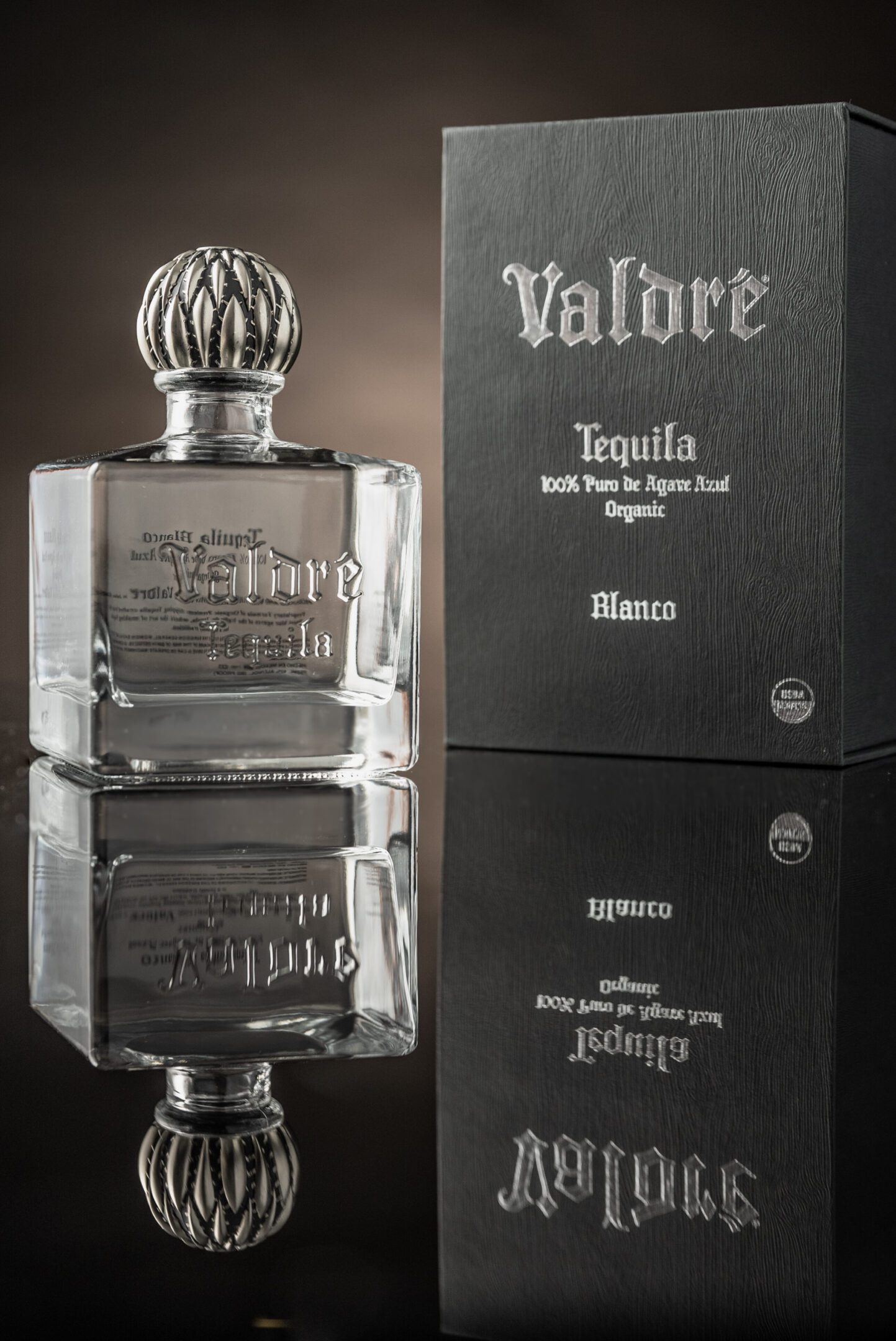 A bottle of tequila with the reflection of it in a mirror.
