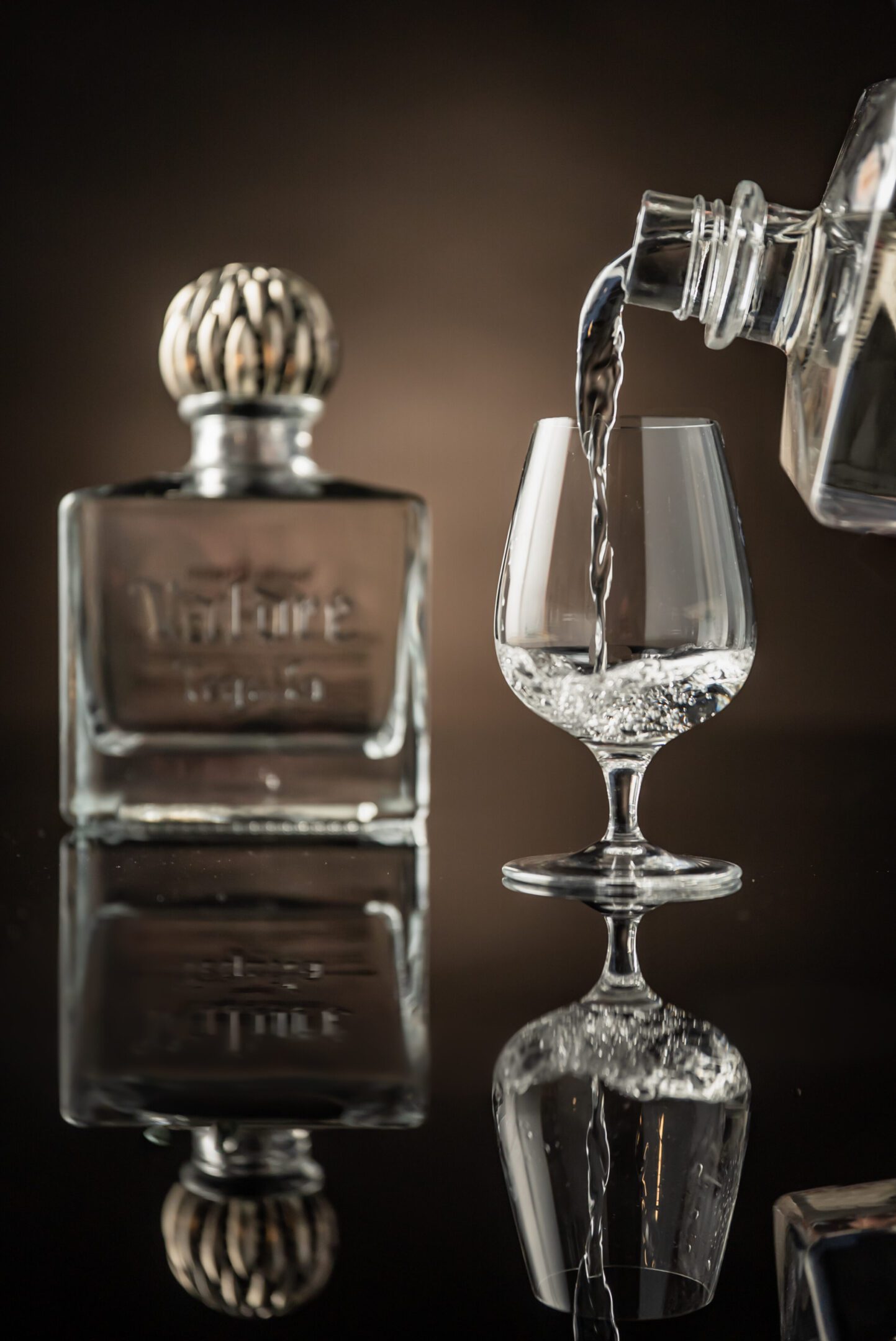 A glass of water is being poured into a wine glass.