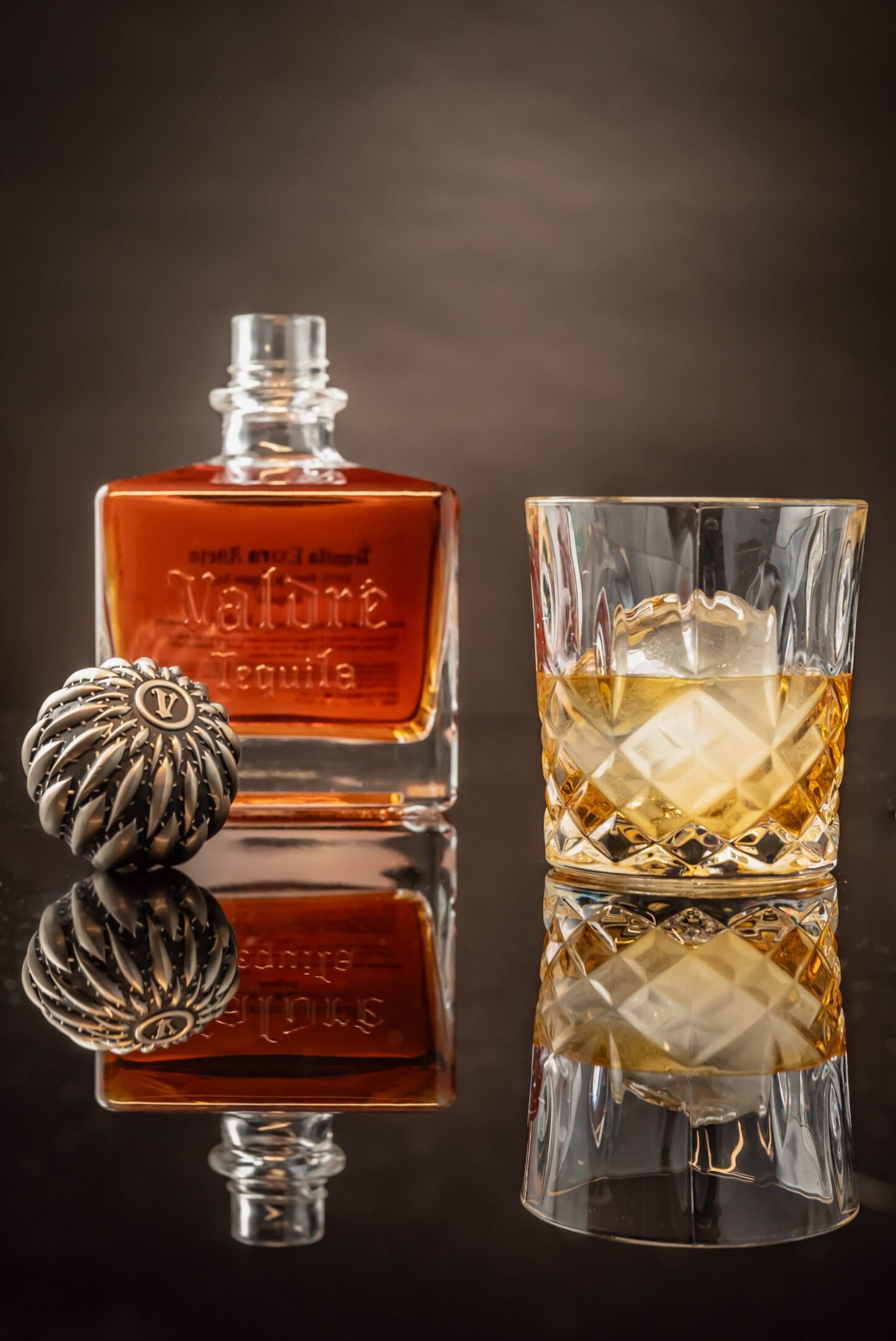 A glass of whiskey and a bottle on the table