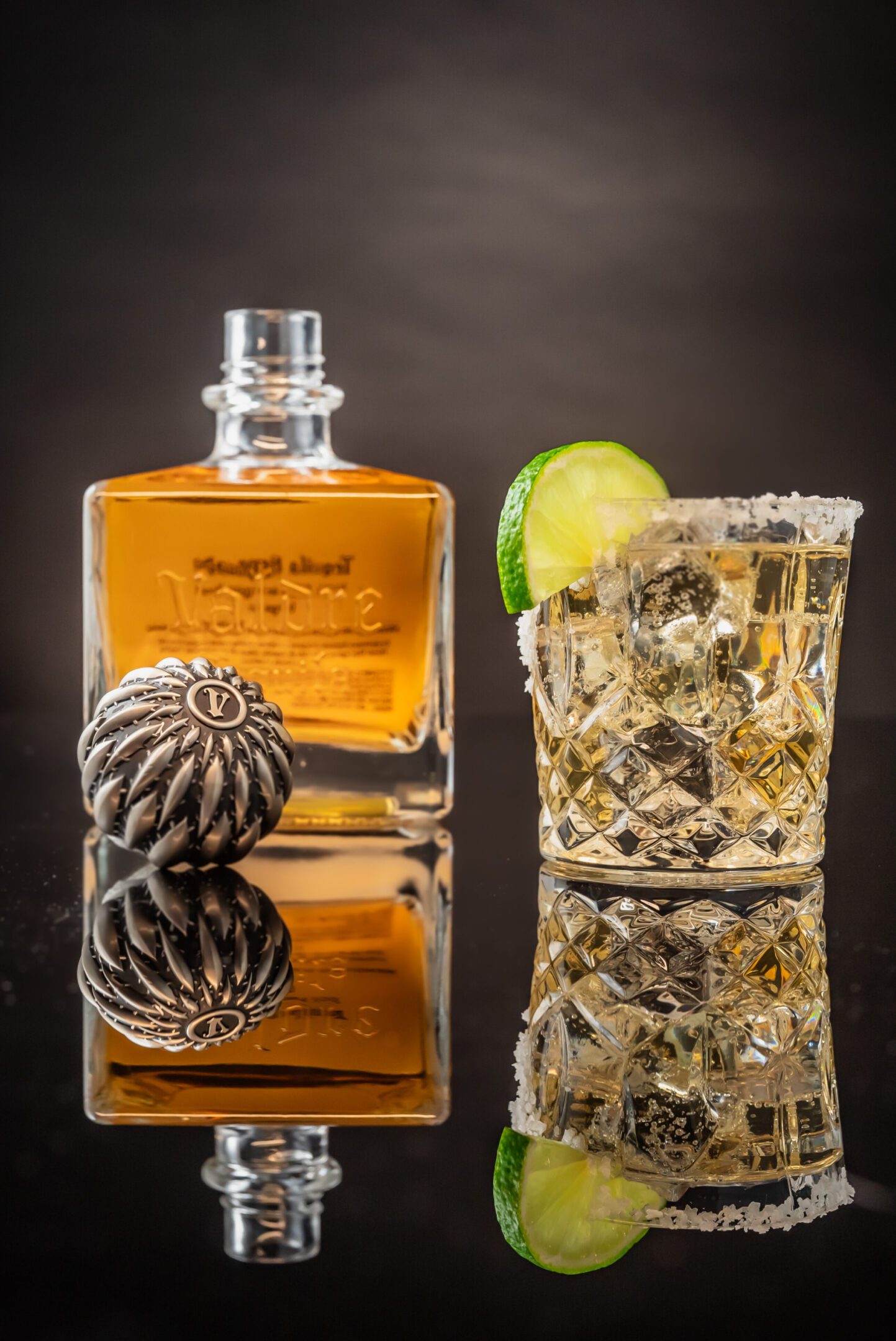 A glass of whiskey and a bottle on the table