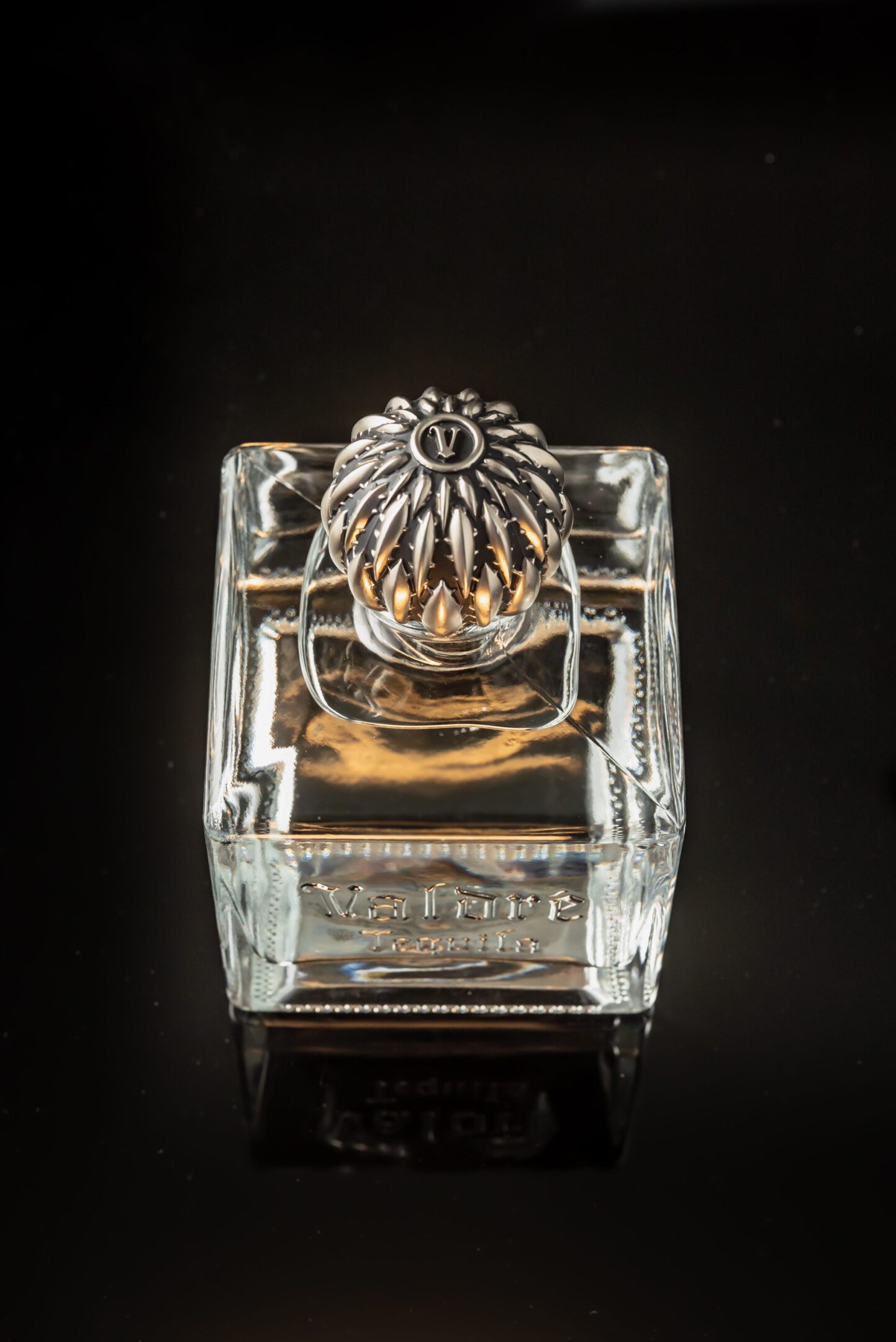 A glass container with a silver lid on top of it.