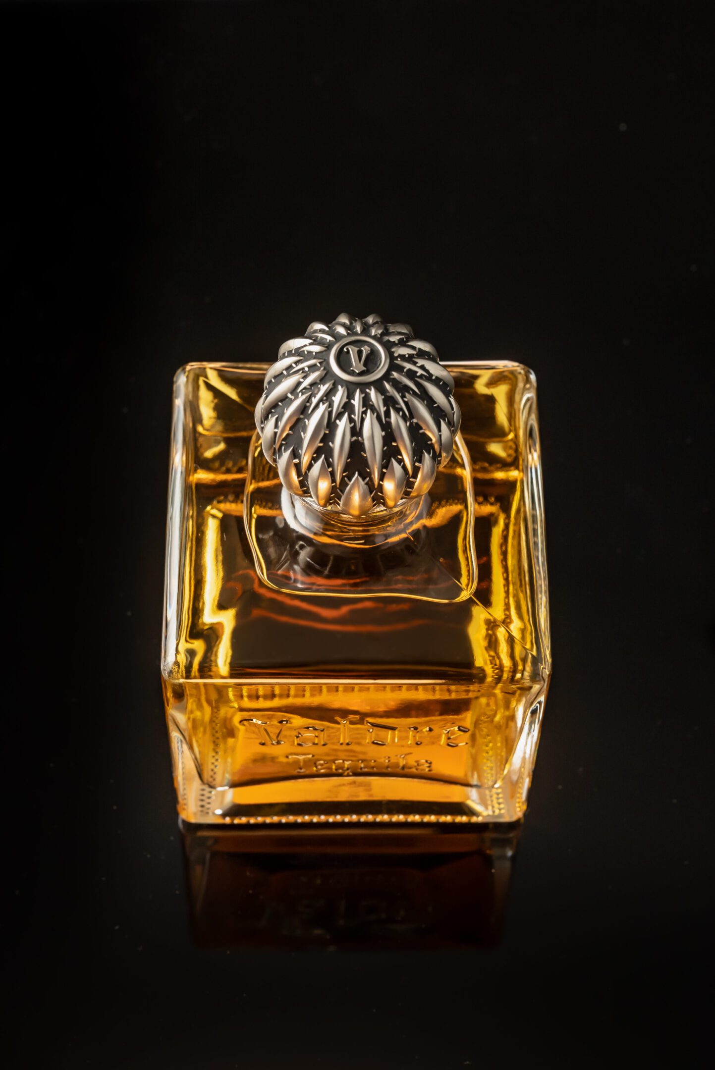 A bottle of perfume with a silver lid.